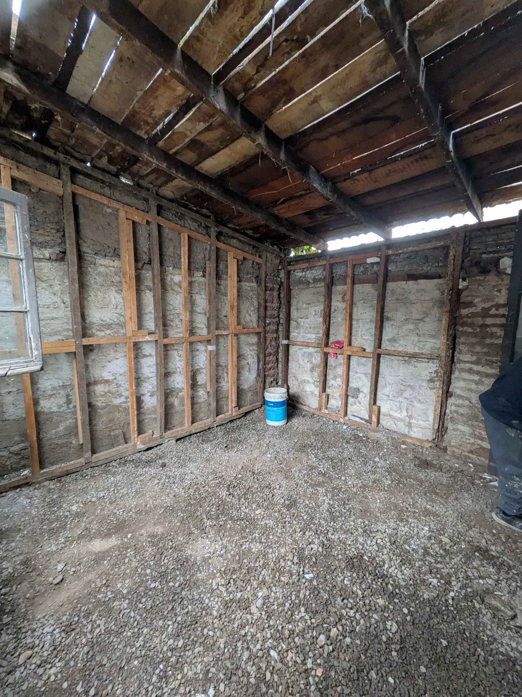 La casa desarmada hasta la estructura, con el entramado del techo a la vista
