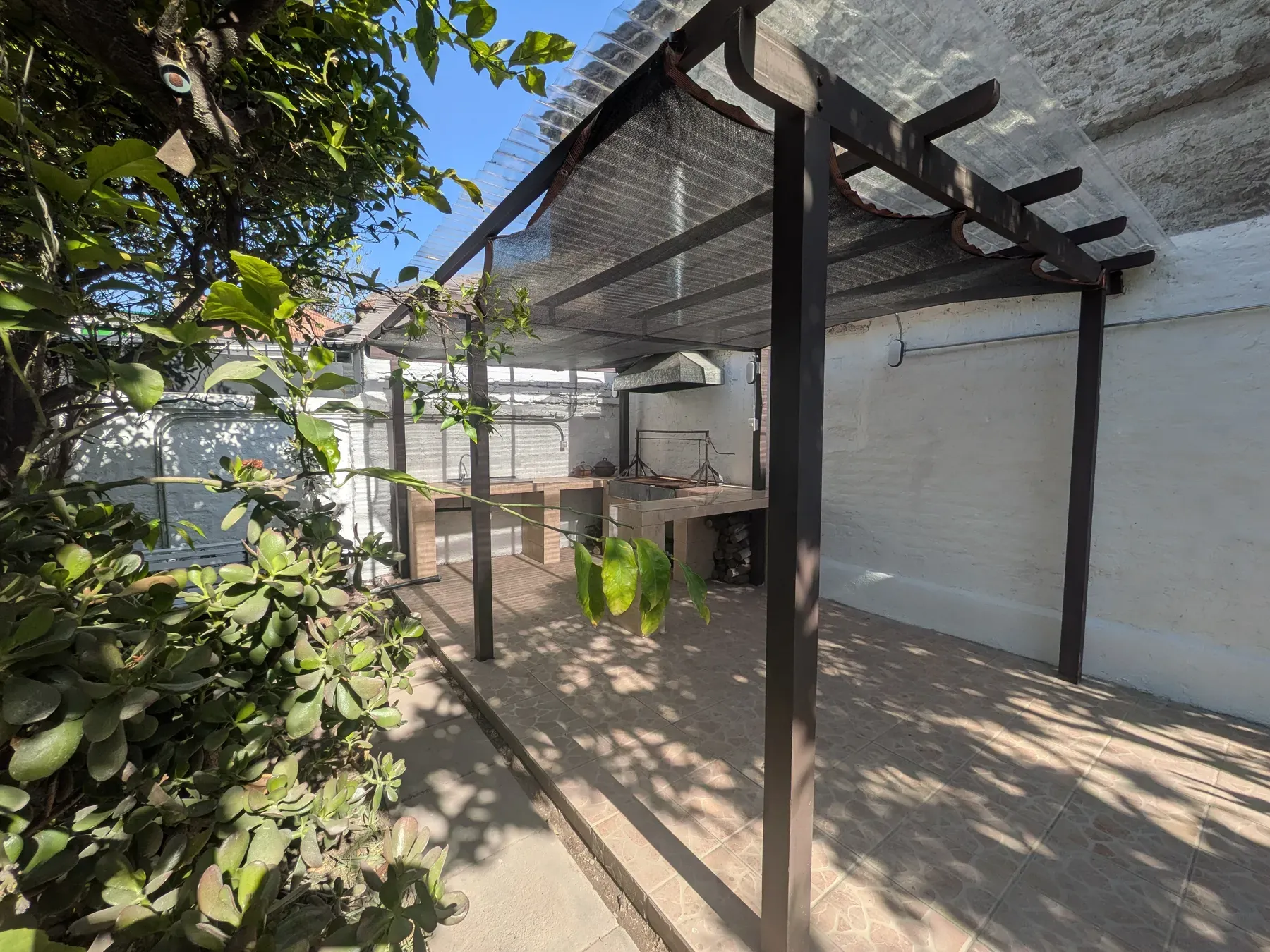 La pérgola nueva sobre el patio, con estructura de madera y cubierta translúcida