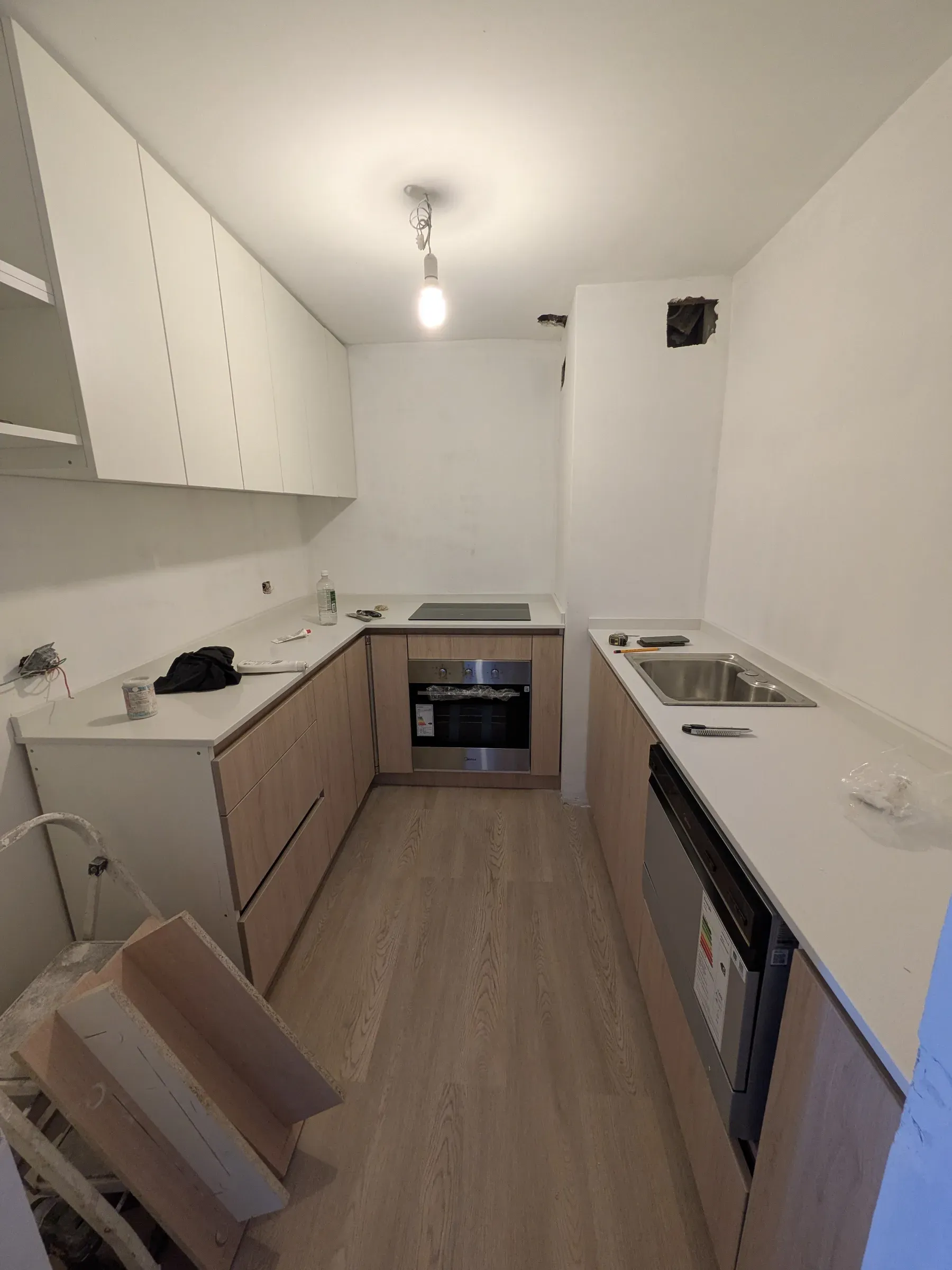 Los muebles ya montados y la encimera puesta, con las instalaciones todavía a la vista
