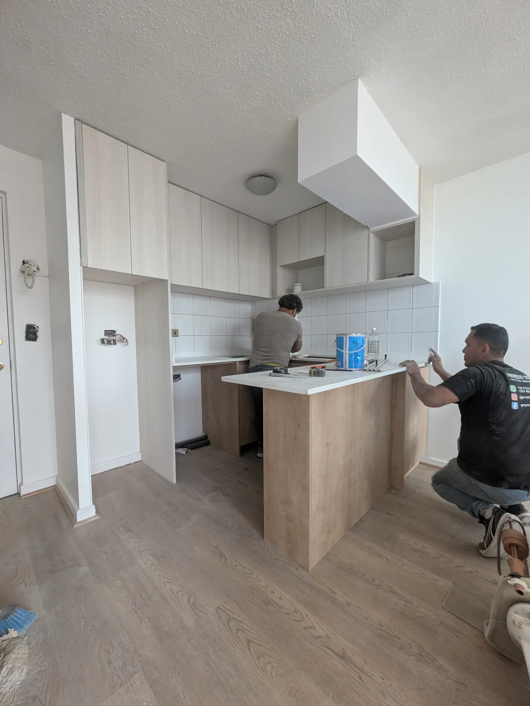 Dos maestros montando la isla y los muebles de cocina a medida